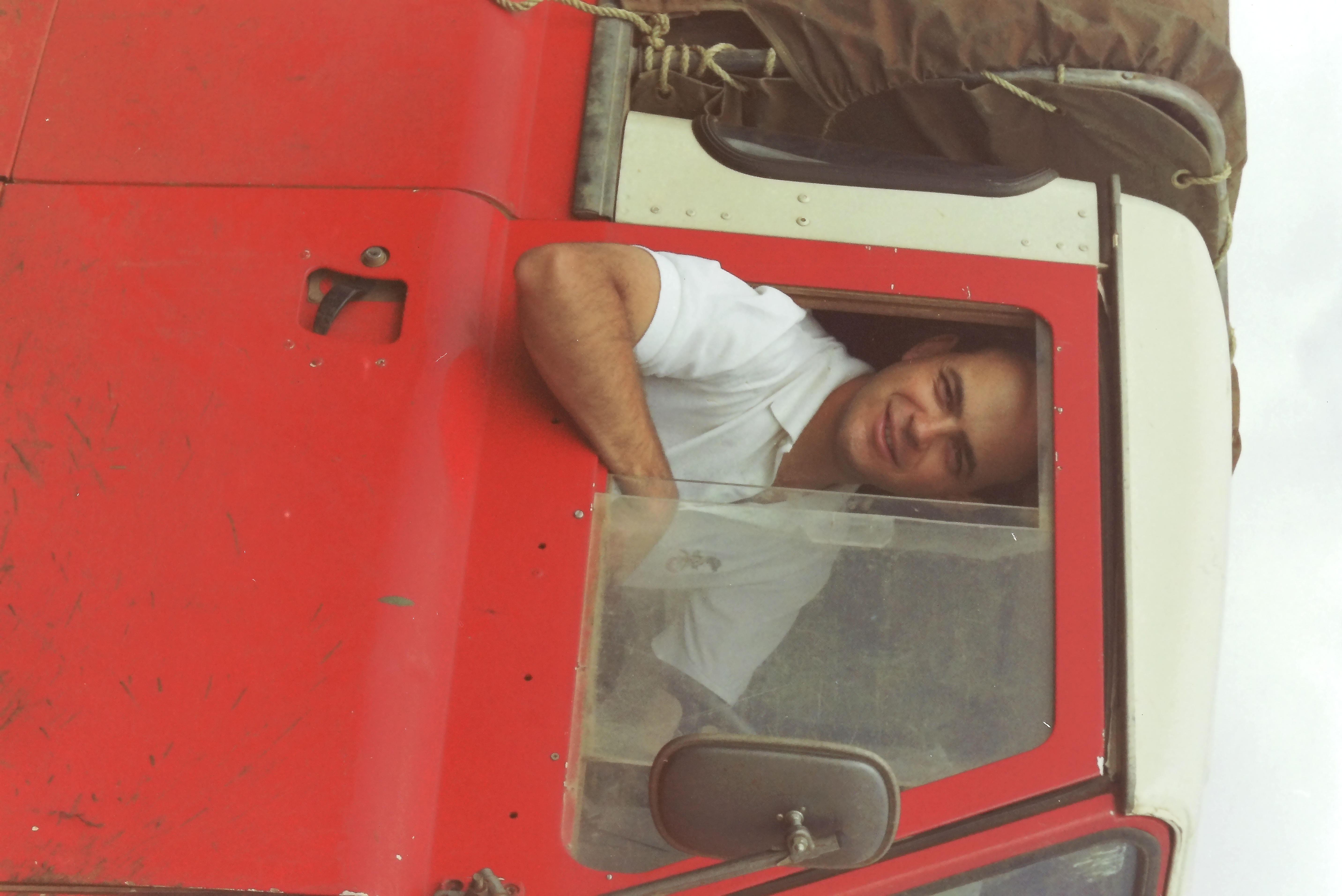 Andre driving red Landy. The roads were so bad in the camp site that the farmer gave us the Landy to use for the weekend